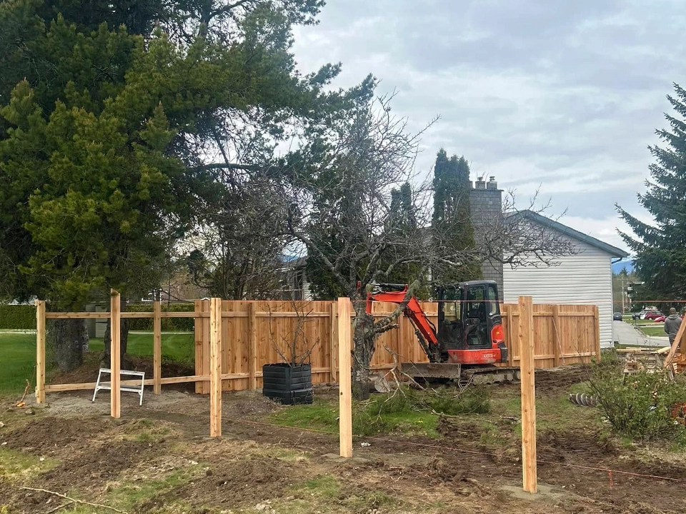 Wood fence installation with post layout and site preparation at residential property
