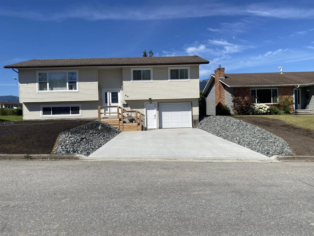 Home with rough graded front yard and finished driveway in a residential development.
